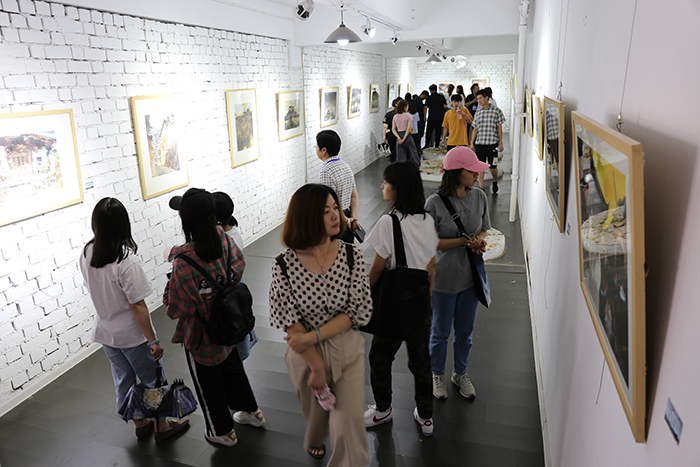 2众多艺术爱好者在开幕式后观看画展.jpg